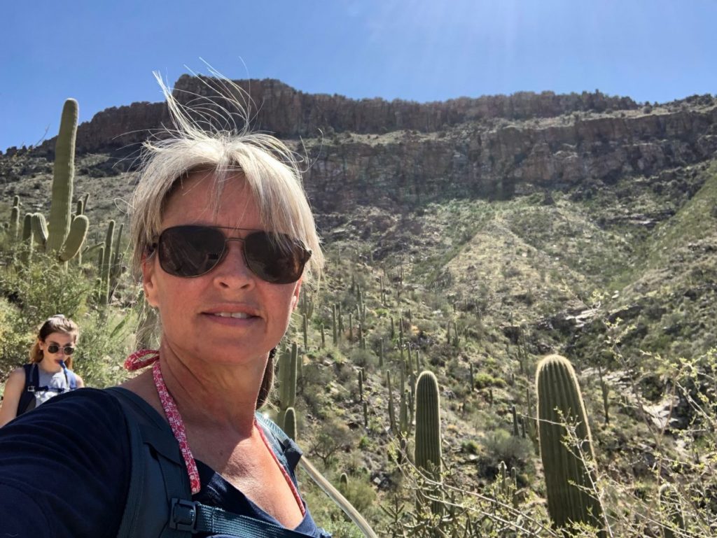 Julie poses with the Saguaros on the Phoneline Trail